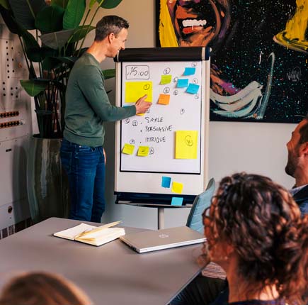 Expert geeft voor whiteboard uitleg tijdens een training over leiderschap